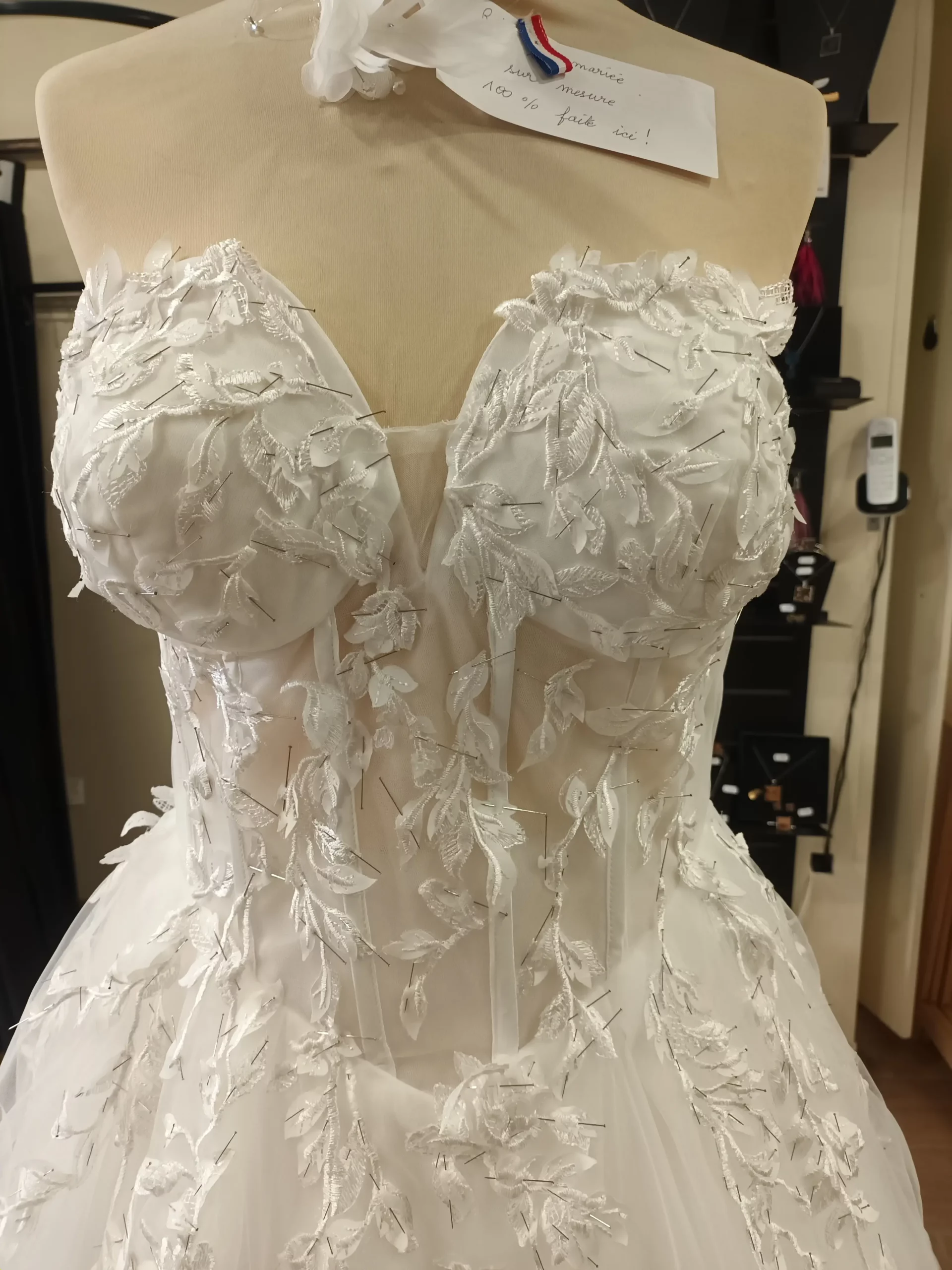 Travail en cours sur une robe de mariée avec épinglage de dentelle